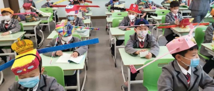 Китайські діти носять в школі чарівні капелюхи соціальної дистанції